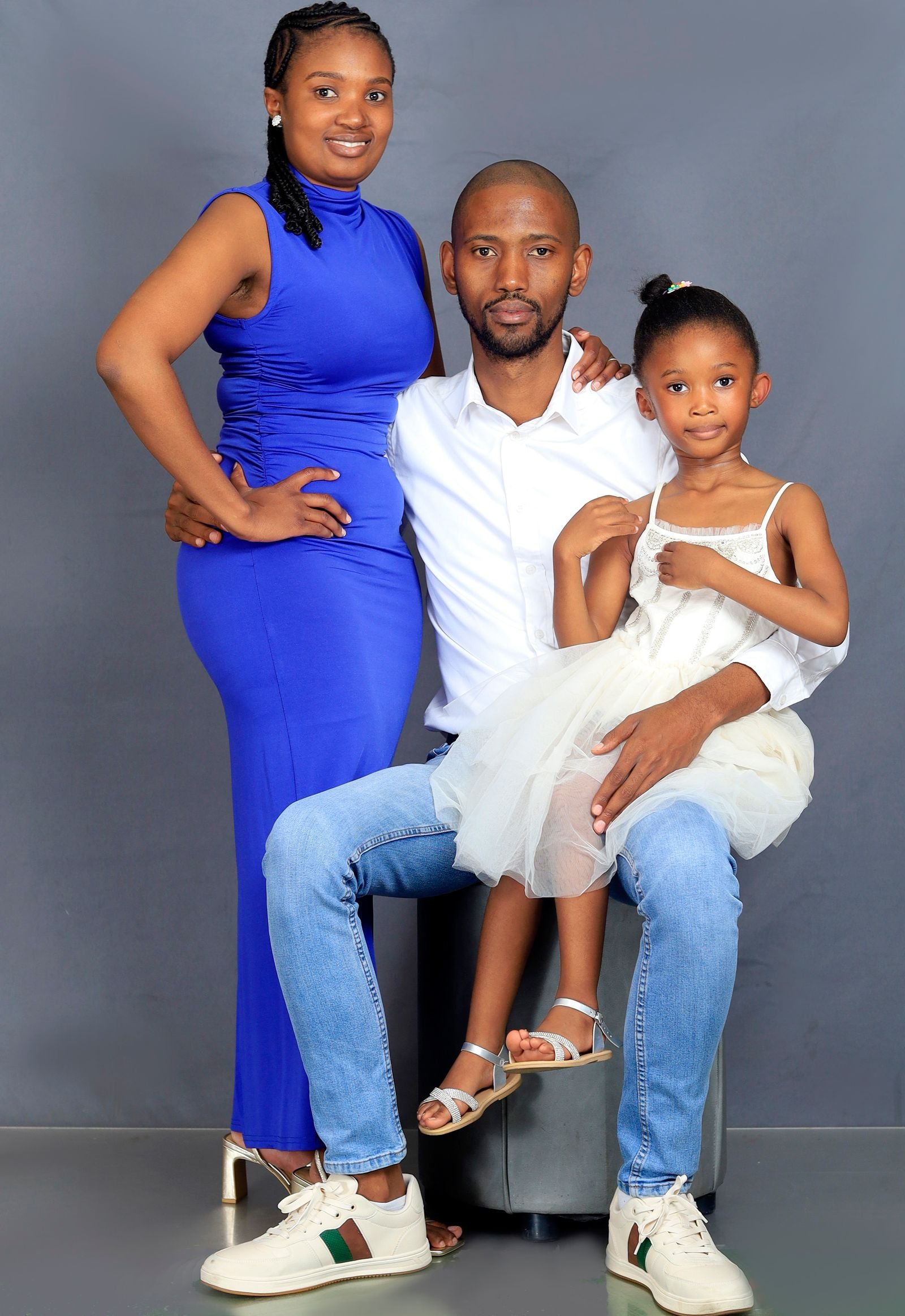 Deux parents et leur enfant assis ensemble dans le salon