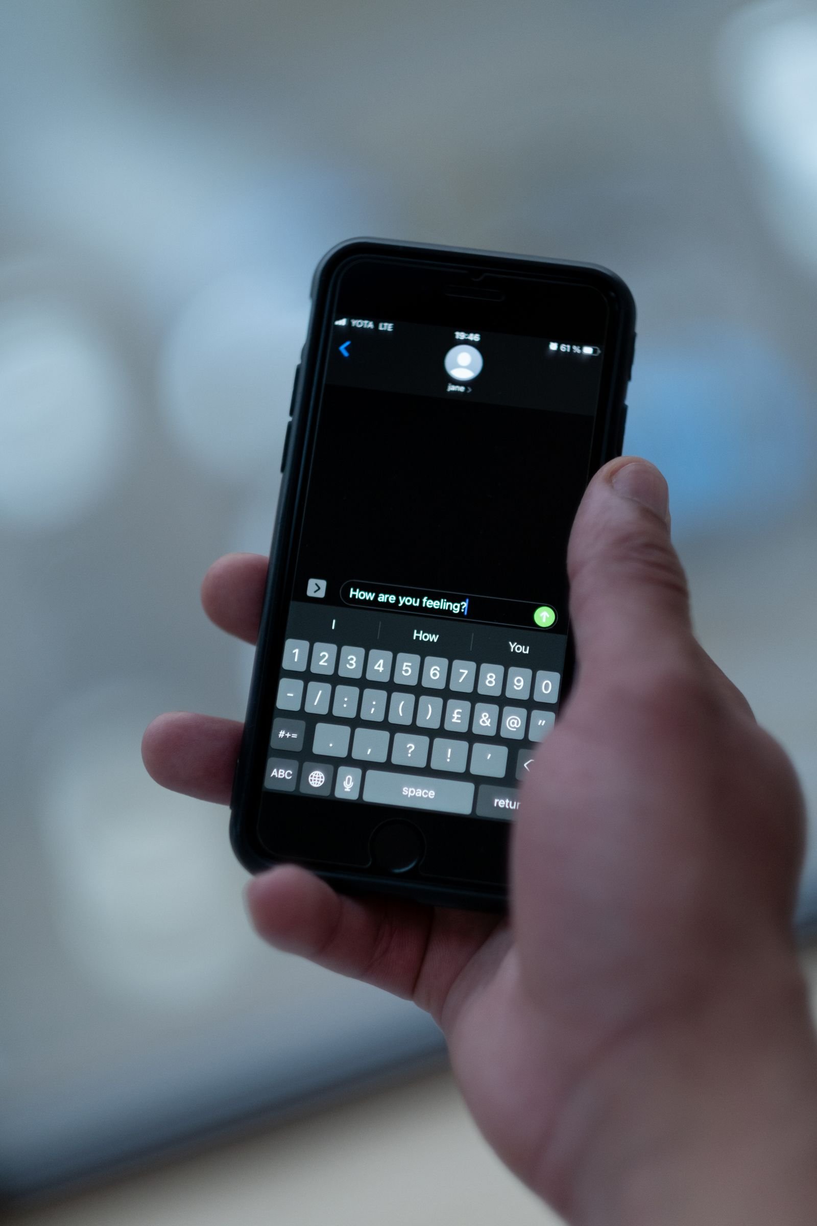 Une main tenant un téléphone ouvert sur une conversation