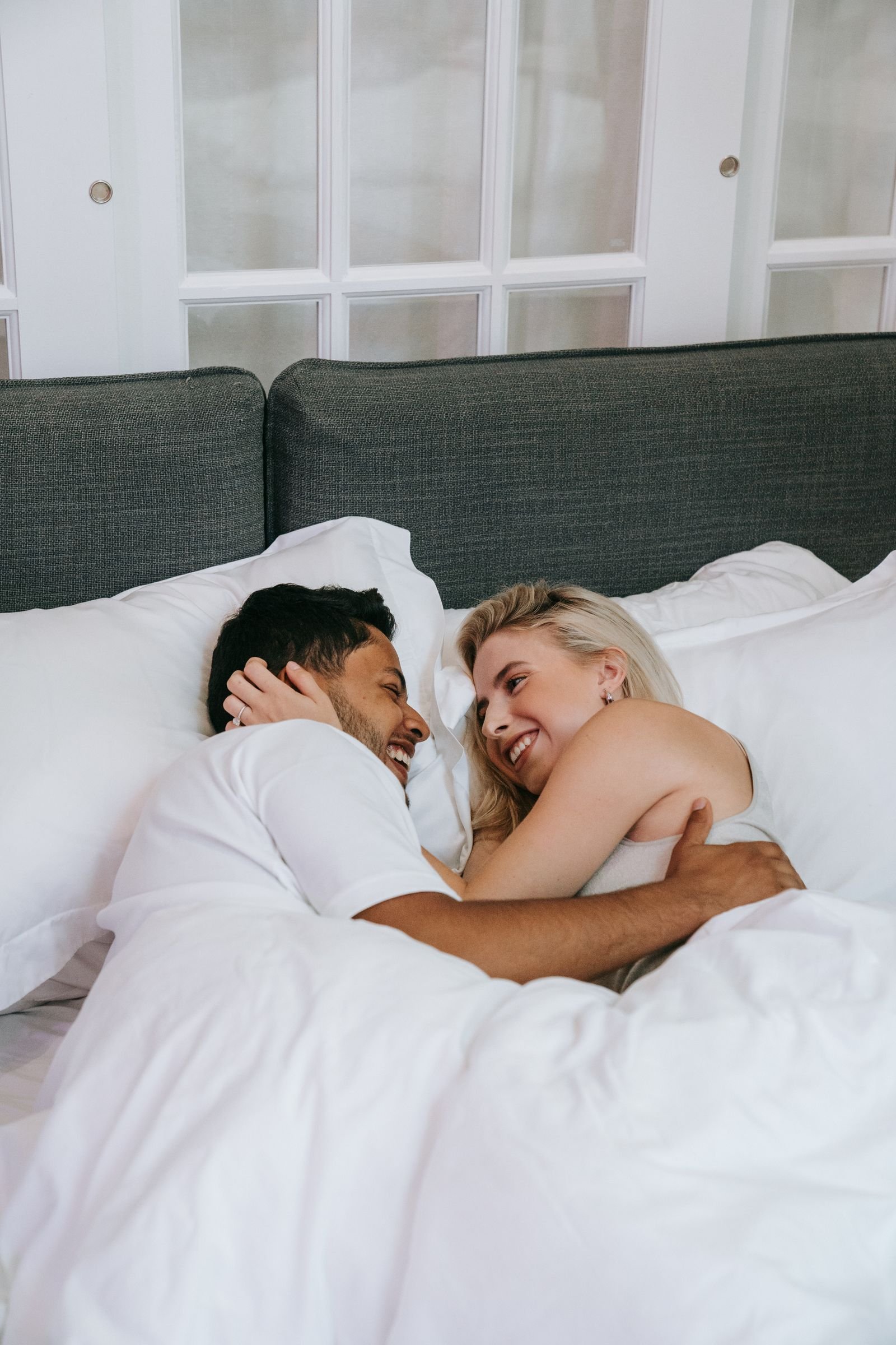Un couple allongé, chacun de son côté du lit